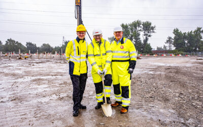 Three SSE representatives in high-visibility workwear put a shovel in the ground to inauguration construction.